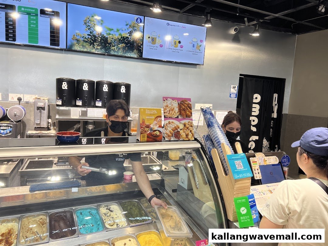An interior view of Amps Tea X Lickers, featuring staff serving ice cream and drinks to a customer.