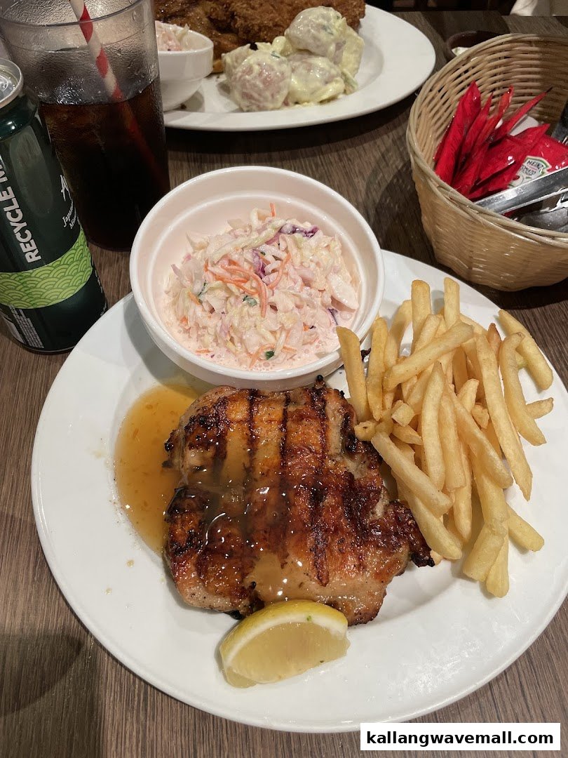 A delicious grilled chicken meal with fries, coleslaw, and a drink at ASTONS Specialities.