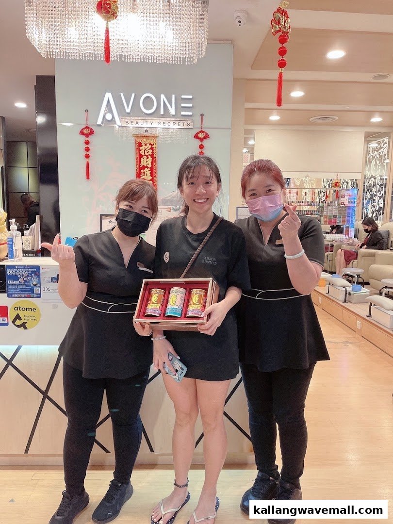 Three smiling individuals, including staff and a customer, pose with a product box inside Avone Beauty Secrets.