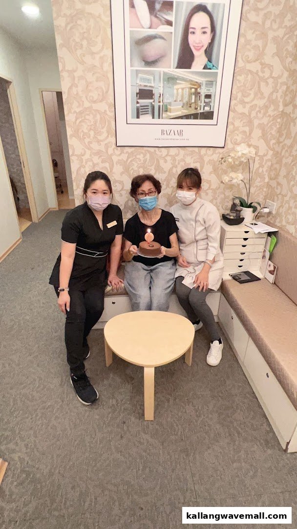 Three women, including staff, celebrating with a cake in the welcoming interior of Avone Beauty Secrets.