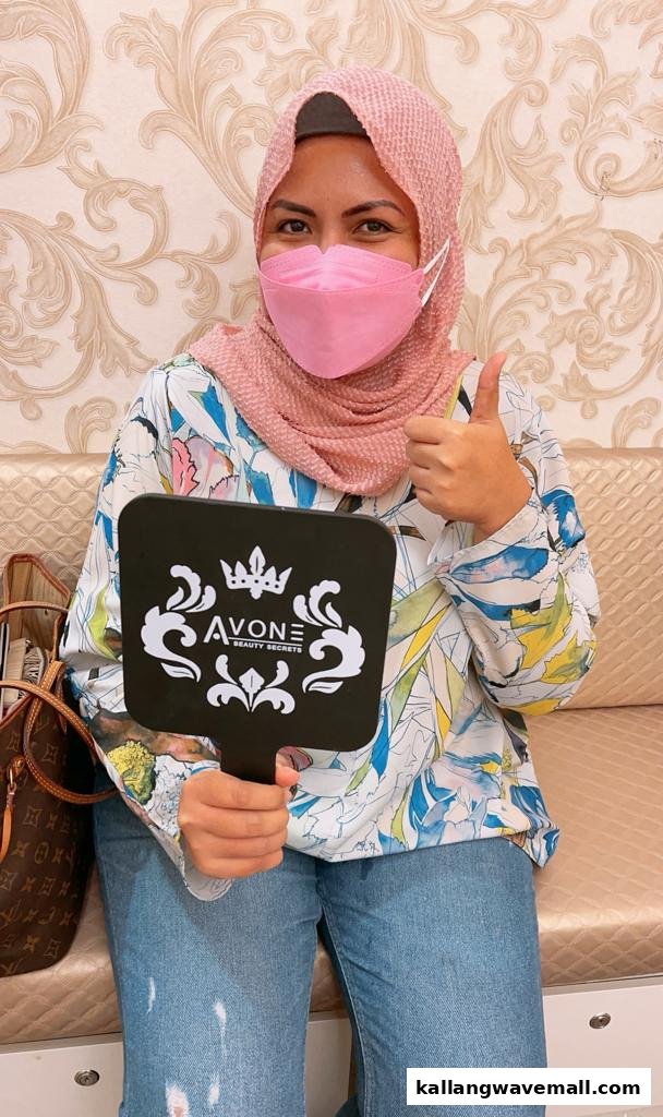 A happy customer in a pink mask gives a thumbs-up, holding an Avone Beauty Secrets branded mirror.