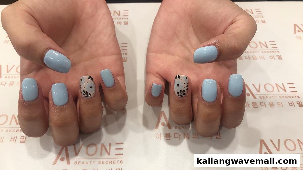 Close-up of hands displaying light blue manicured nails, one with a delicate floral accent design.