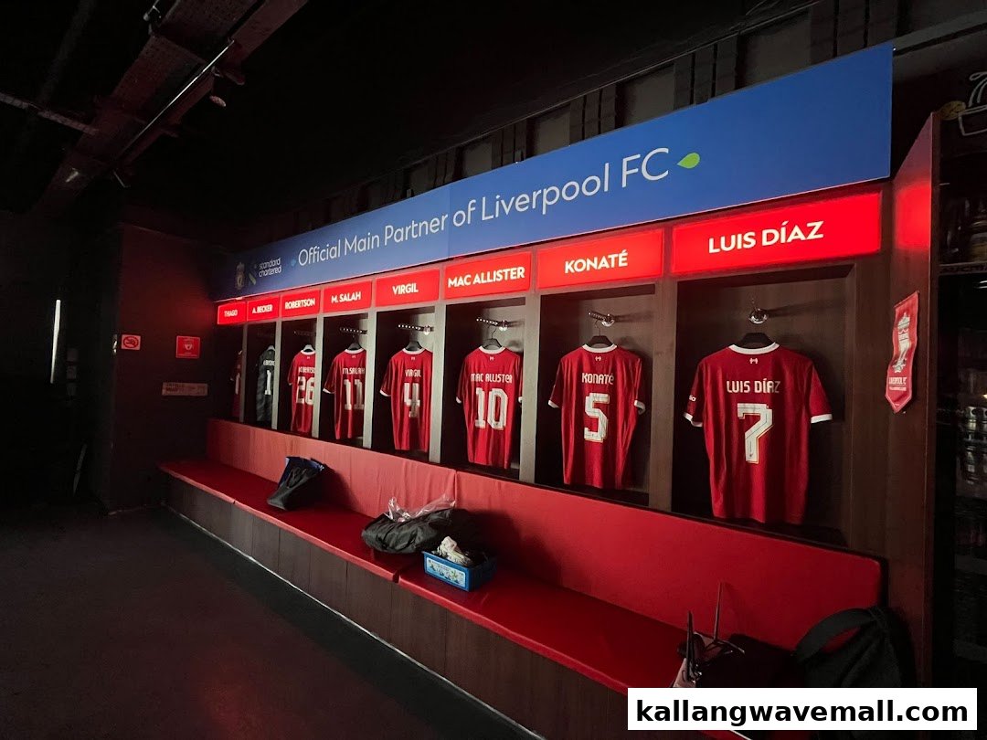 Liverpool FC jerseys displayed in a locker room-style setting, featuring player names and numbers.