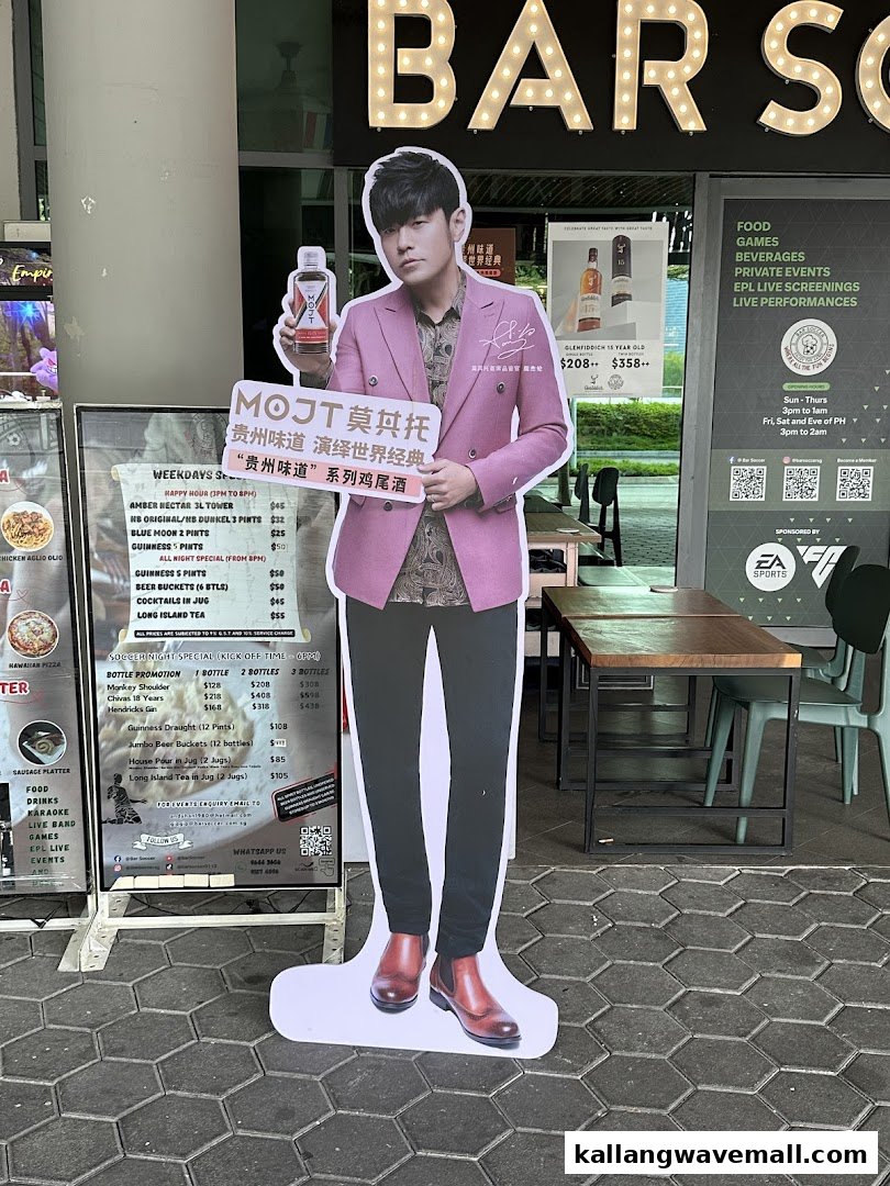 The entrance of Bar Soccer featuring a celebrity standee, outdoor seating, and a menu board.