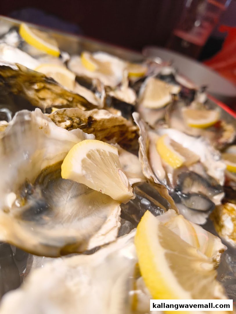 A close-up of fresh oysters on ice, garnished with bright lemon wedges, ready to be enjoyed.
