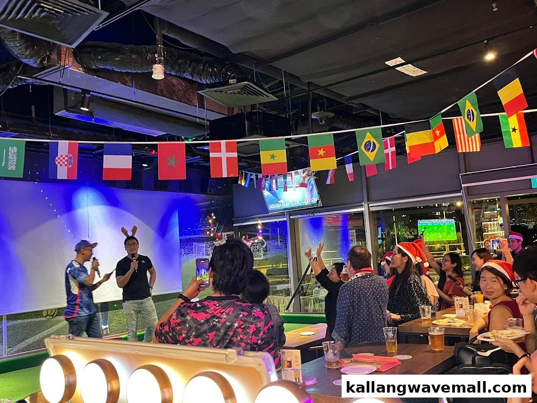 Lively indoor event at Bar Soccer with people, flags, and a stage, celebrating a festive occasion.