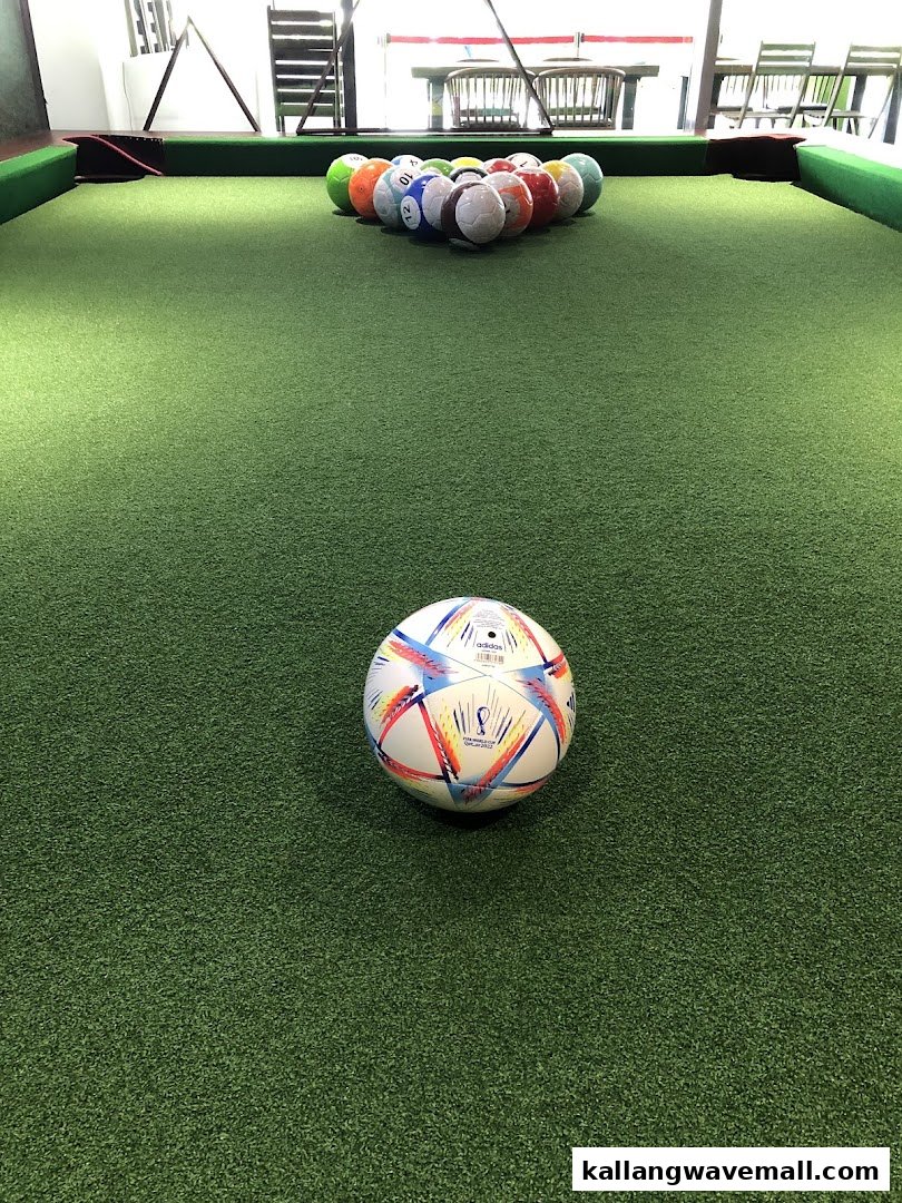 A soccer-themed pool table with soccer ball-shaped pool balls and a FIFA World Cup ball.