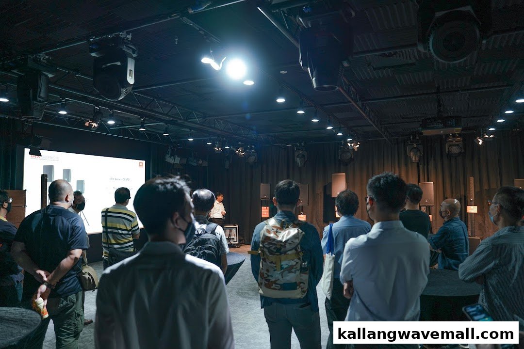 Attendees observe a product demonstration featuring audio equipment in a modern media lab setting.