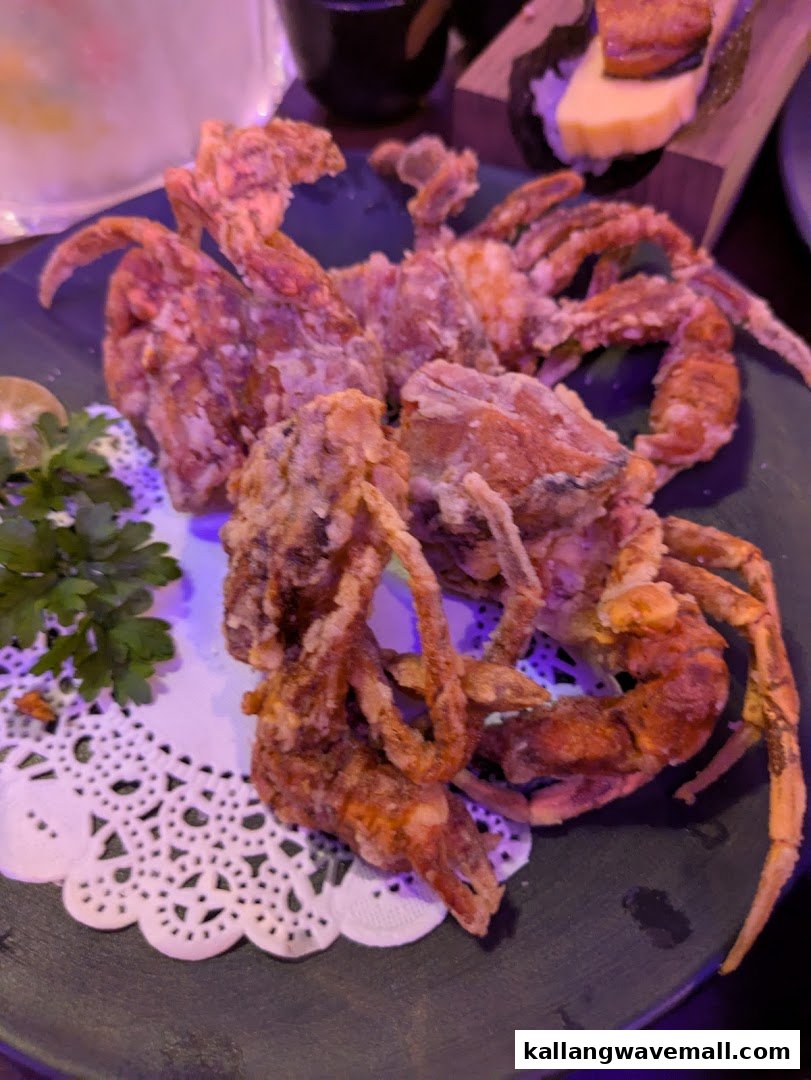 A plate of crispy fried soft-shell crabs garnished with parsley and lime.