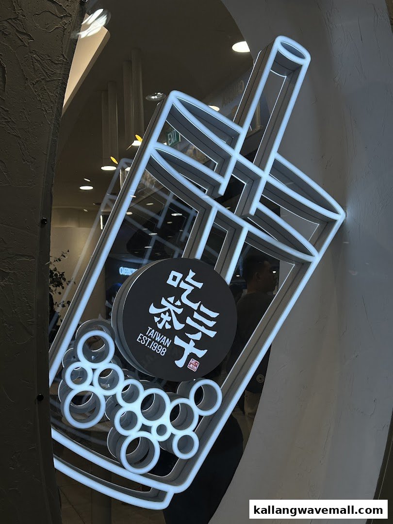 A vibrant neon sign shaped like a bubble tea cup with the shop's logo, 'CHICHA San Chen'.