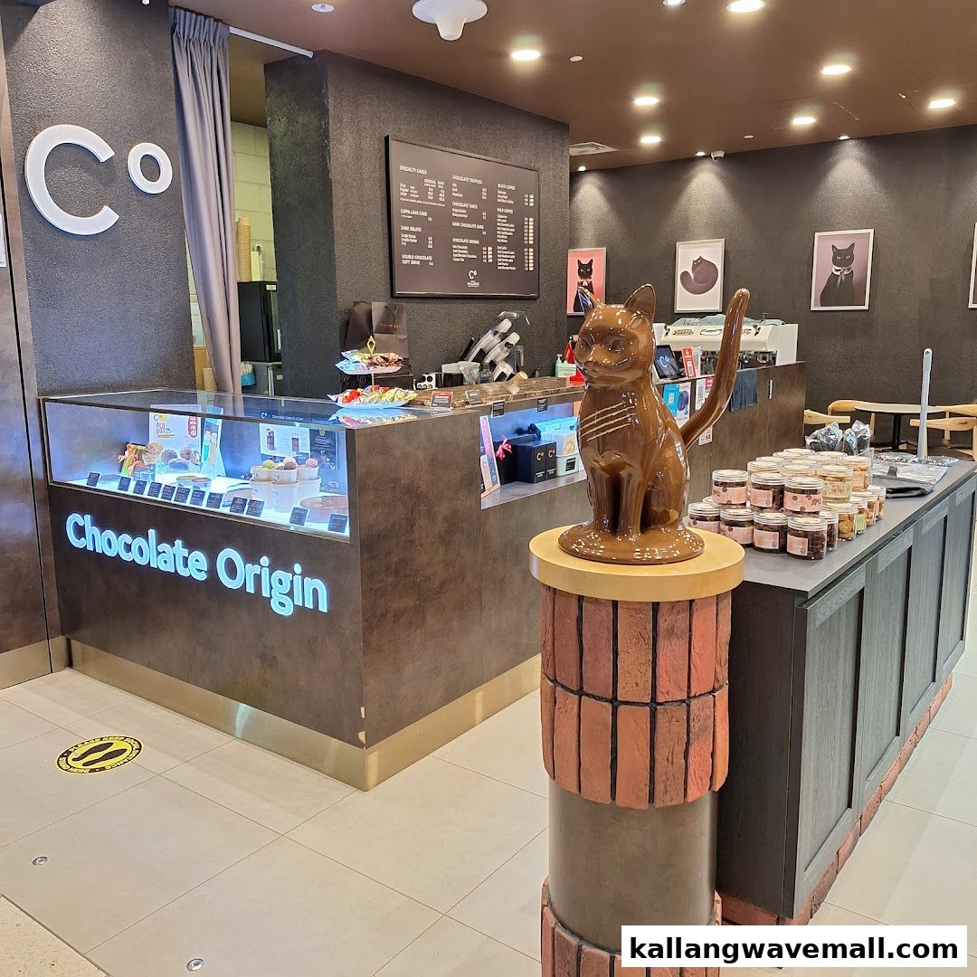 Interior view of Chocolate Origin, showcasing display counter, a chocolate cat statue, and menu board.