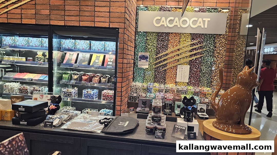 Interior view of a chocolate shop featuring cat-themed products, displays, and a large chocolate cat sculpture.