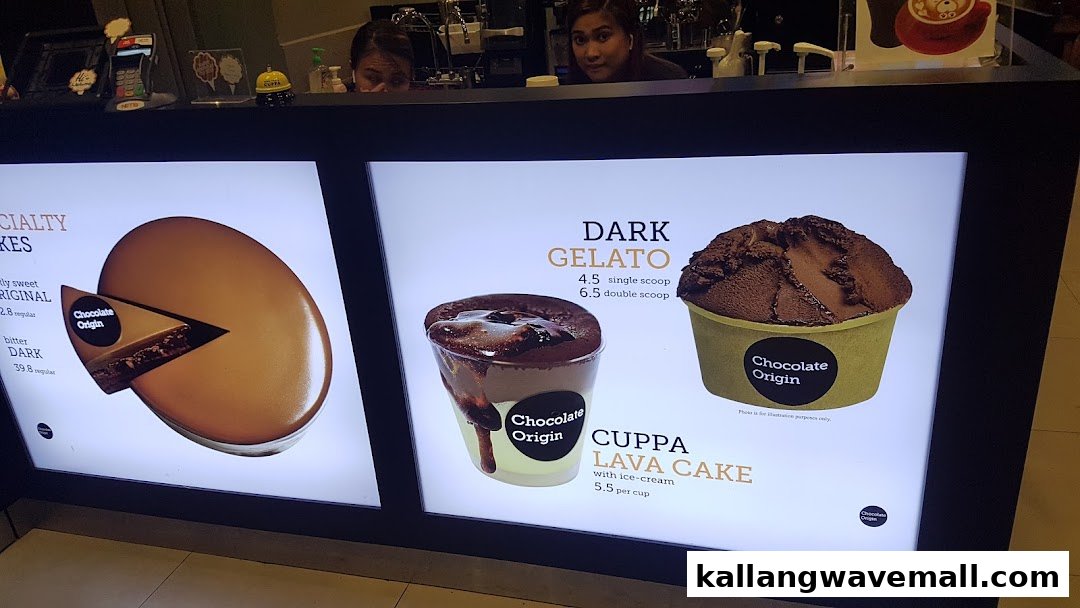 Illuminated menu boards display Chocolate Origin's specialty cakes, dark gelato, and cuppa lava cake.