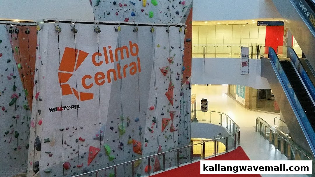 A vibrant indoor climbing wall with the 'Climb Central' logo, featuring various colorful holds and auto-belay systems.