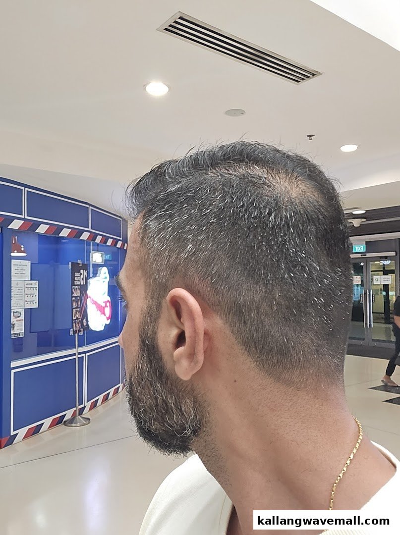 A man with a fresh haircut and beard looking towards Clippers Barber.