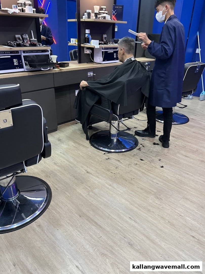 A barber gives a customer a haircut inside a modern barbershop.