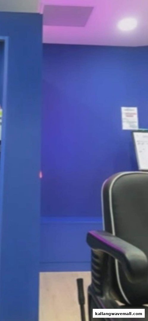 Interior view of Clippers Barber, featuring a black barber chair against blue walls.