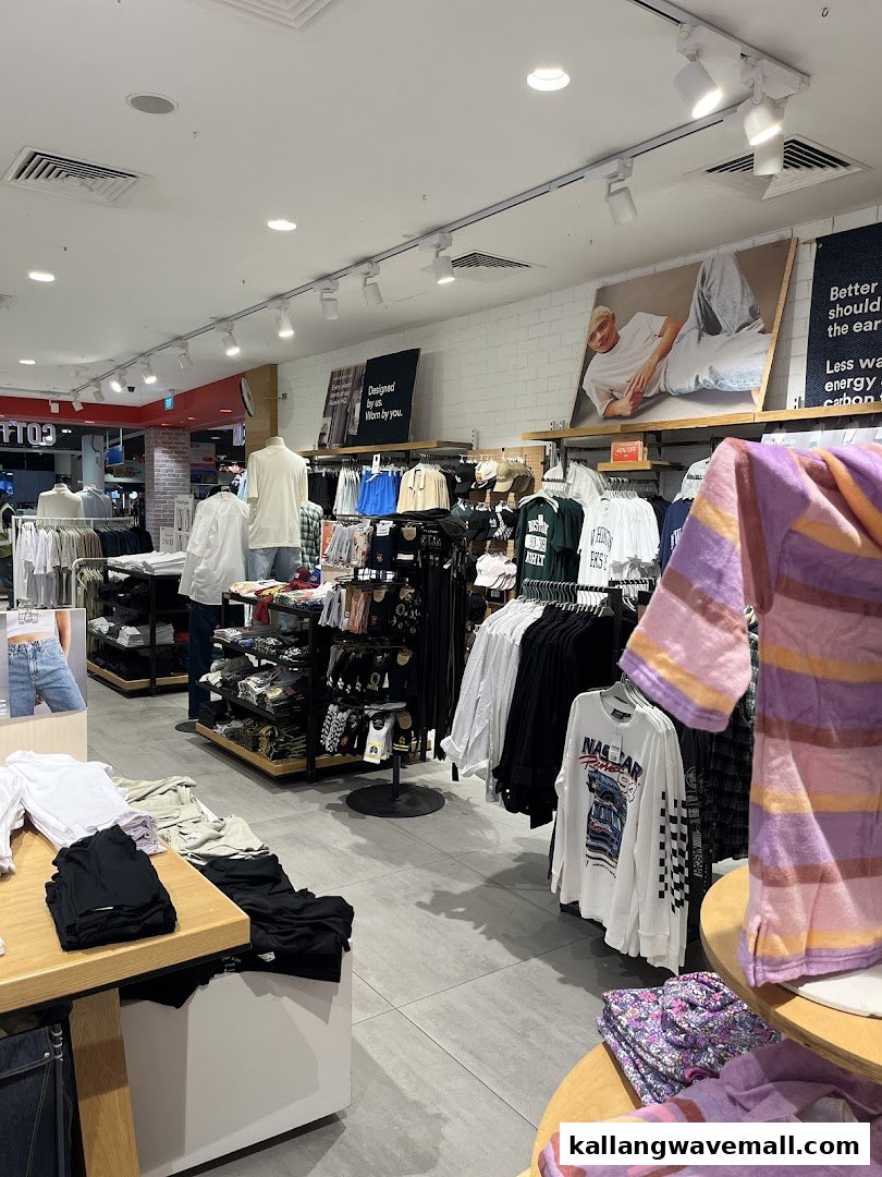 An interior view of Cotton On Sports Hub, showcasing various clothing items on racks, display tables, and mannequins.