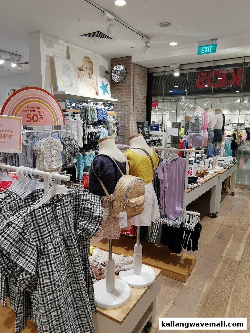 Interior view of Cotton On Sports Hub, displaying casual clothing, mannequins, and sale promotions.
