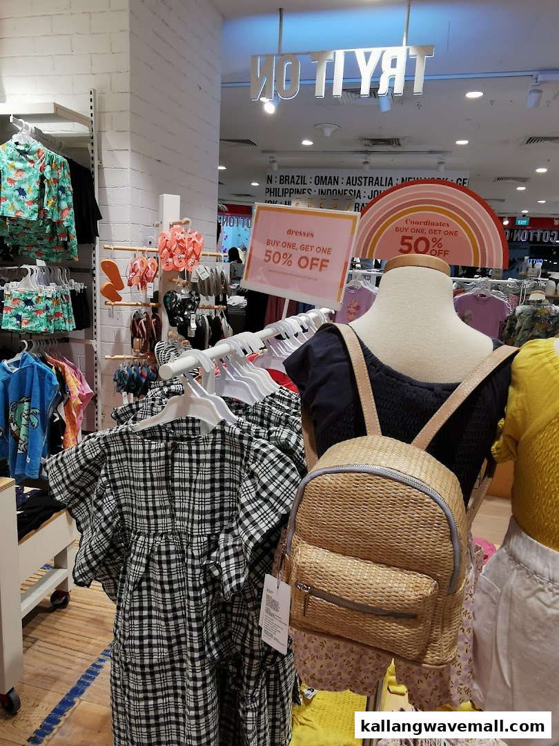Interior view of Cotton On Sports Hub, featuring clothing racks, a mannequin with a backpack, and sale signs.