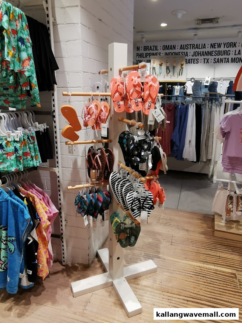 An interior view of Cotton On, showcasing colorful flip-flops and children's apparel on display.