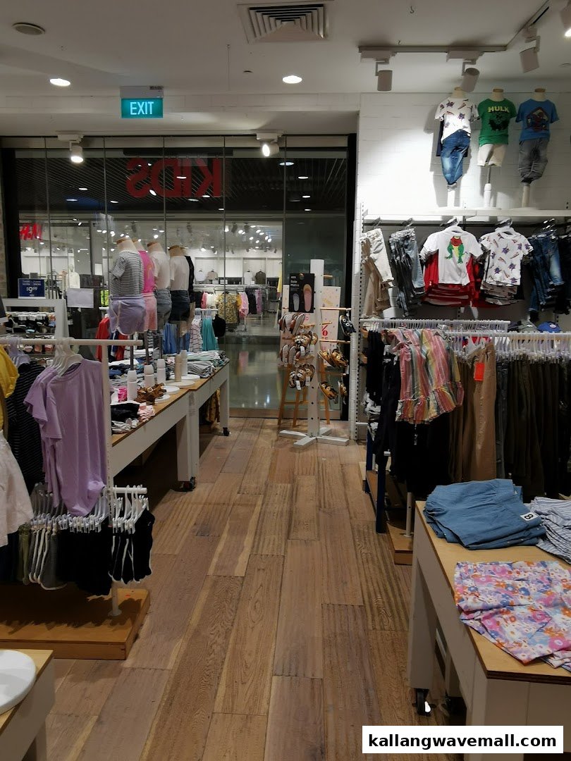 Interior view of Cotton On Sports Hub, featuring diverse apparel on display racks and mannequins.
