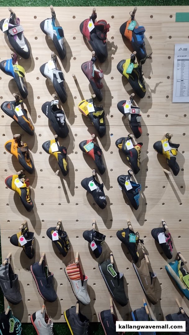 A wall display showcasing a wide variety of climbing and casual shoes for sale.