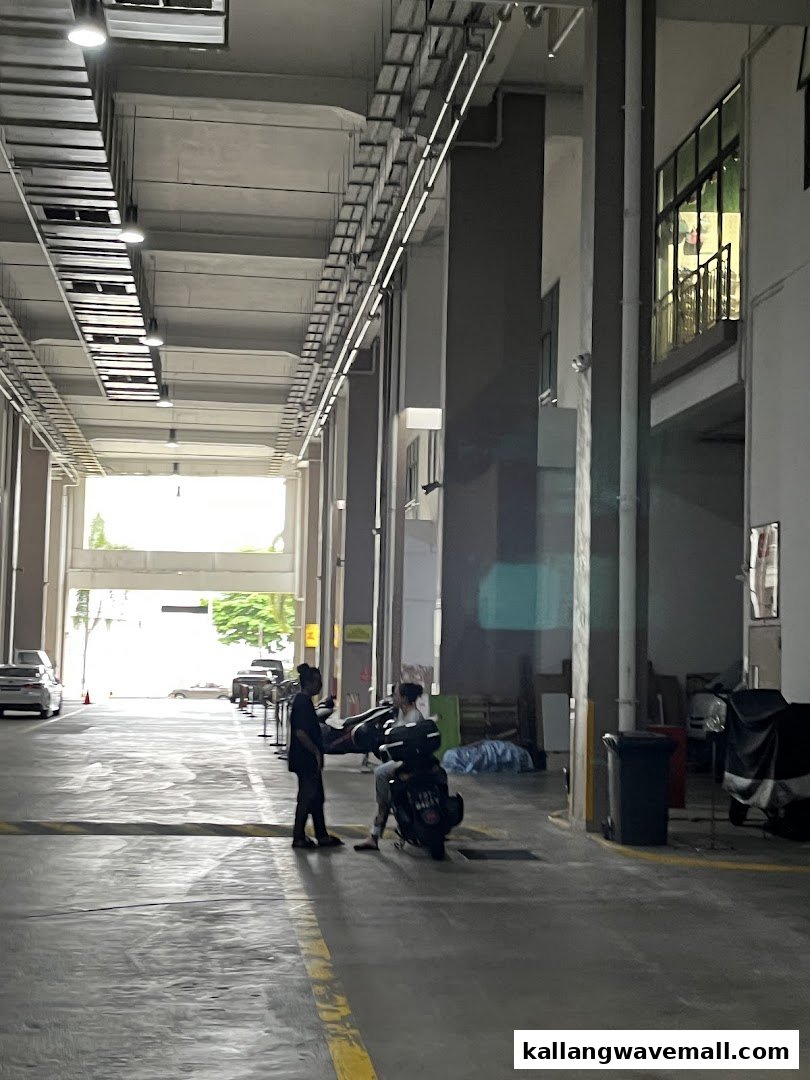 An industrial-style indoor area with people and a scooter, possibly an entrance or loading bay for the facility.