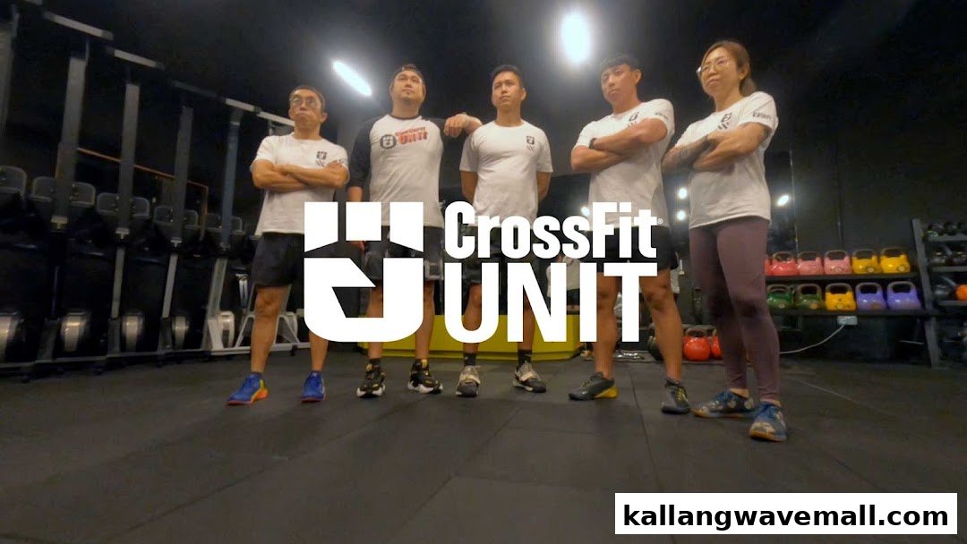 Five individuals, likely trainers or members, stand confidently in a well-equipped CrossFit gym.