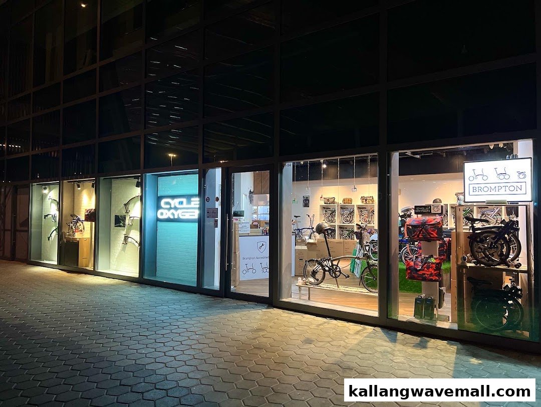 Illuminated storefront of CycleOxygen at night, showcasing bicycles and accessories in its display windows.