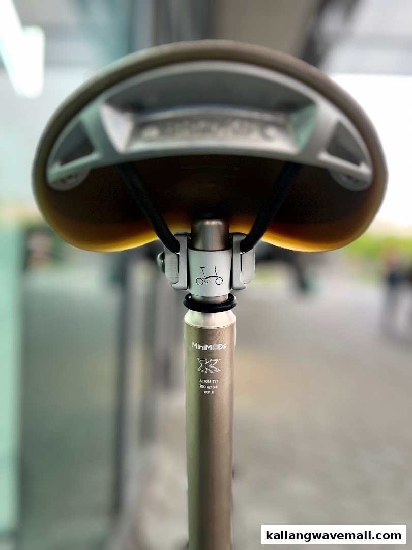 Close-up of a bicycle saddle and seatpost, showcasing detailed components and branding like MiniMODs.