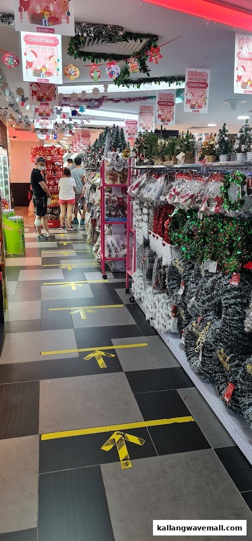 An aisle inside Daiso, featuring Christmas decorations, shoppers, and social distancing floor markers.