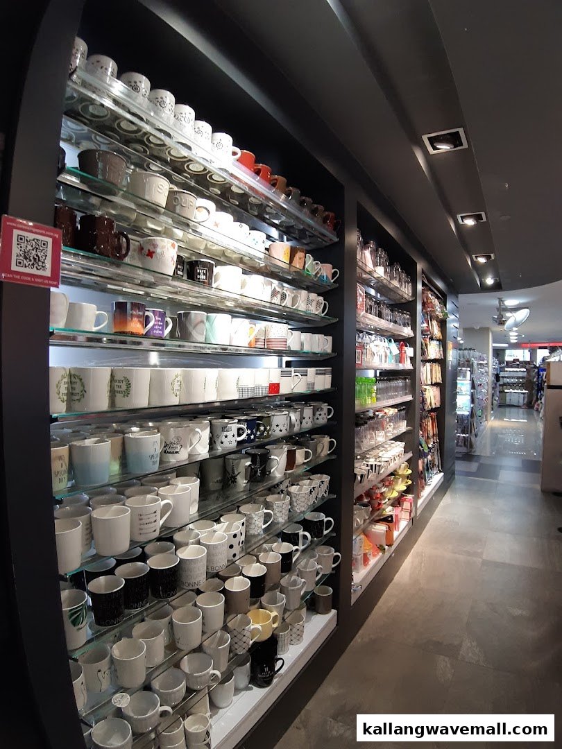 Rows of diverse mugs and household items displayed on shelves inside a retail store.