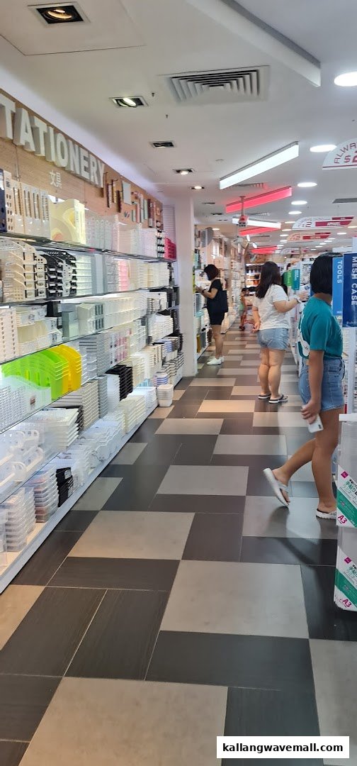 Shoppers browse aisles filled with diverse storage and stationery items inside a brightly lit Daiso store.