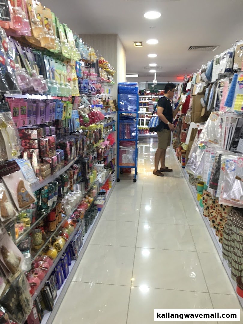 A customer browses a narrow, brightly lit aisle filled with diverse household goods and novelty items at Daiso.
