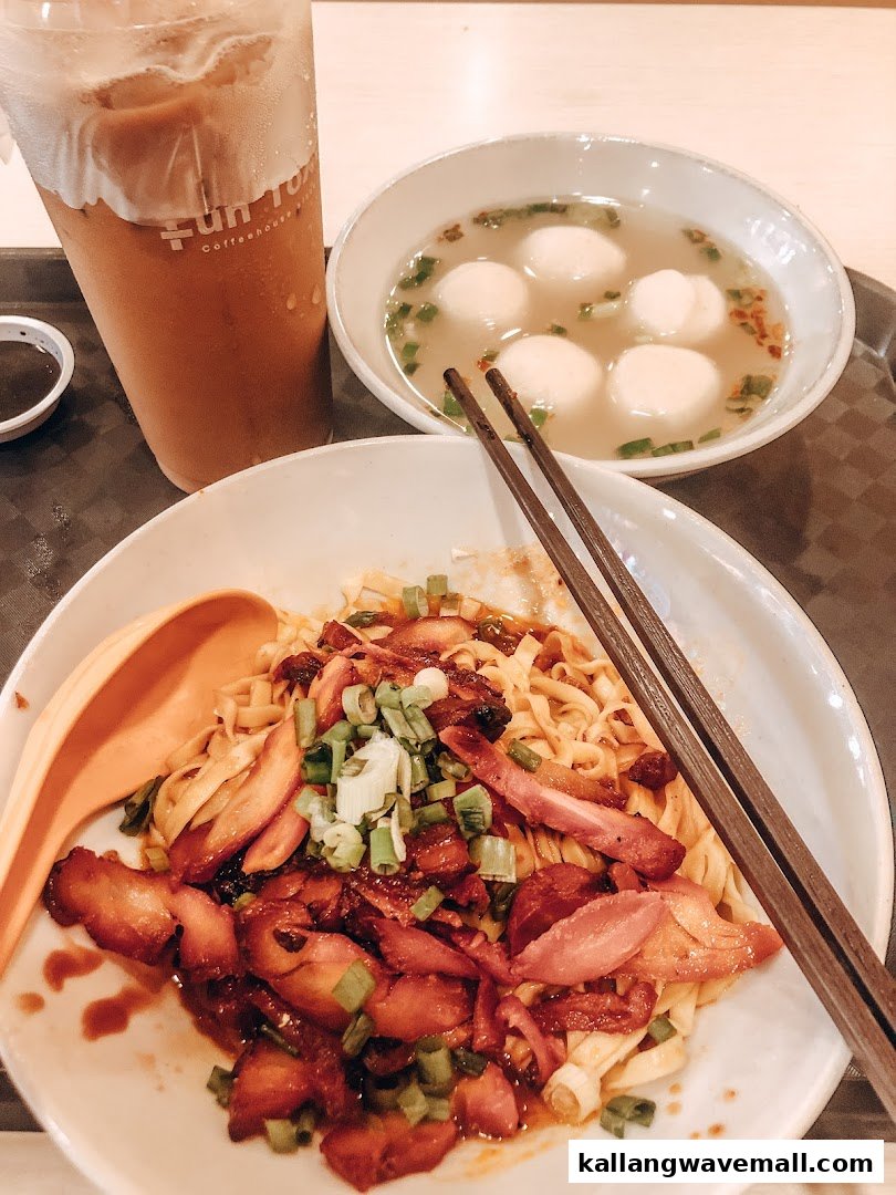 A plate of char siew noodles, a bowl of fishball soup, and an iced drink on a tray.