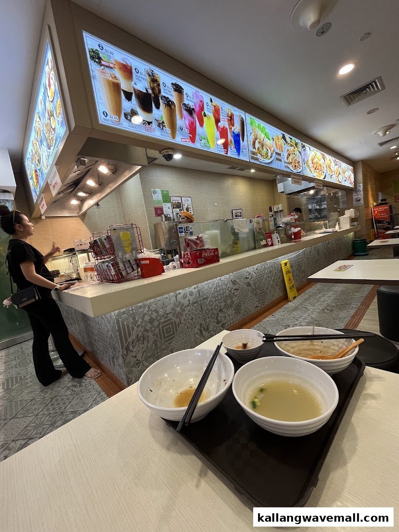 Interior view of Encik Tan, showing the counter, menu boards, and a customer.