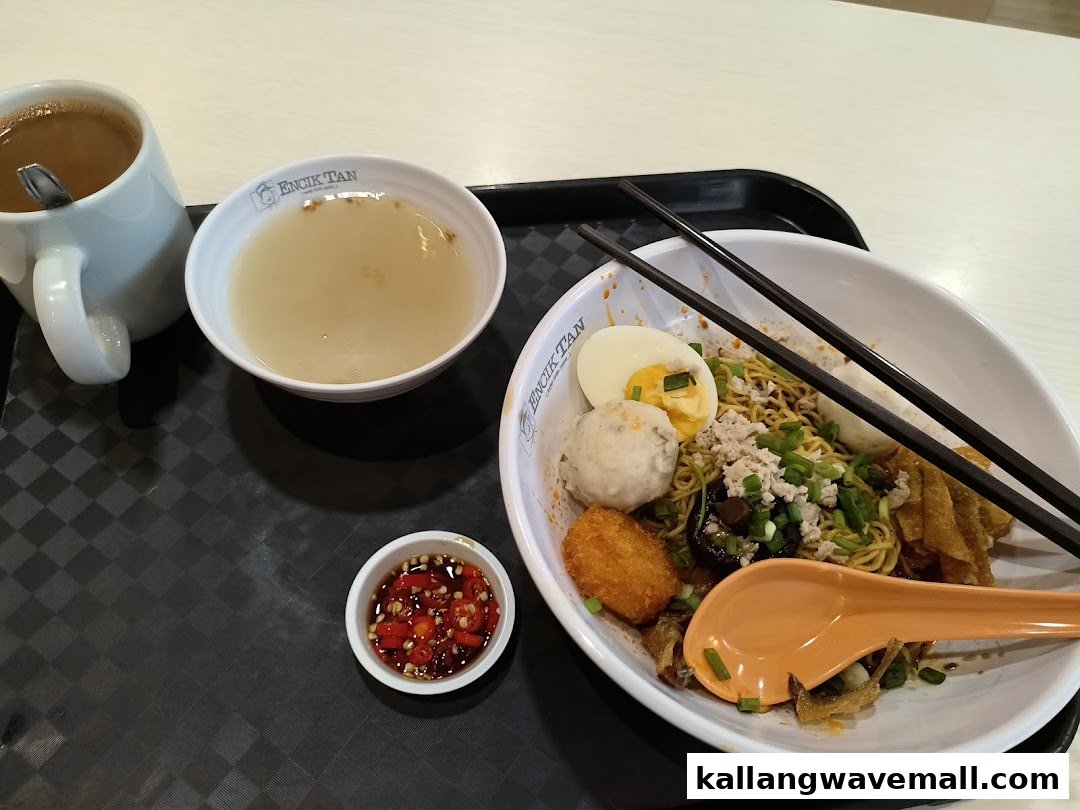 A delicious bowl of dry noodles with toppings, soup, and a drink from Encik Tan.