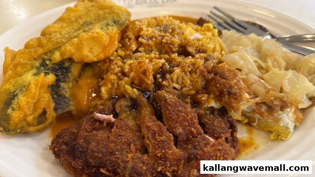 A close-up of a hearty plate of rice with fried chicken, fried fish, and vegetables from Encik Tan.