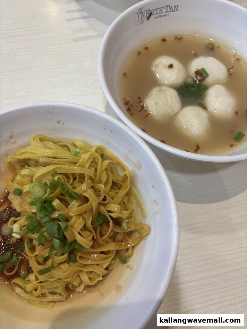 A close-up of dry noodles with sauce and a bowl of fishball soup from Encik Tan.