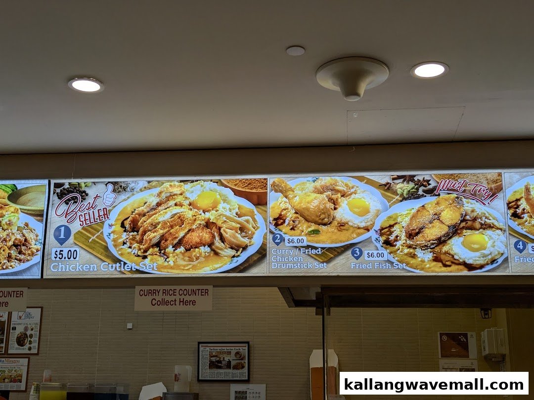 A brightly lit menu board displaying various curry rice sets with images and prices at Encik Tan.