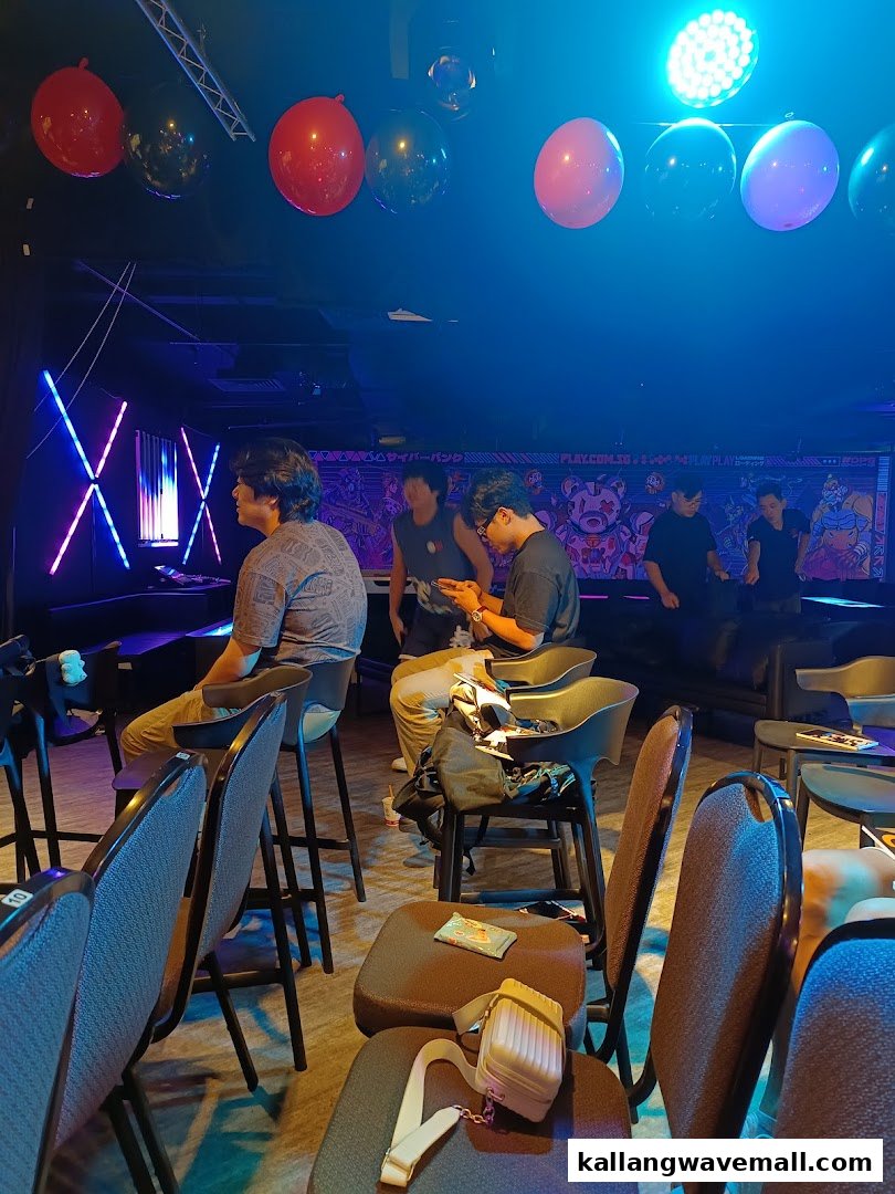 People gather in a dimly lit esports center with neon lights and gaming decor.