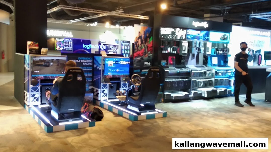 An interior view of an Esports Experience Center featuring racing simulators, gaming product displays, and a staff member.