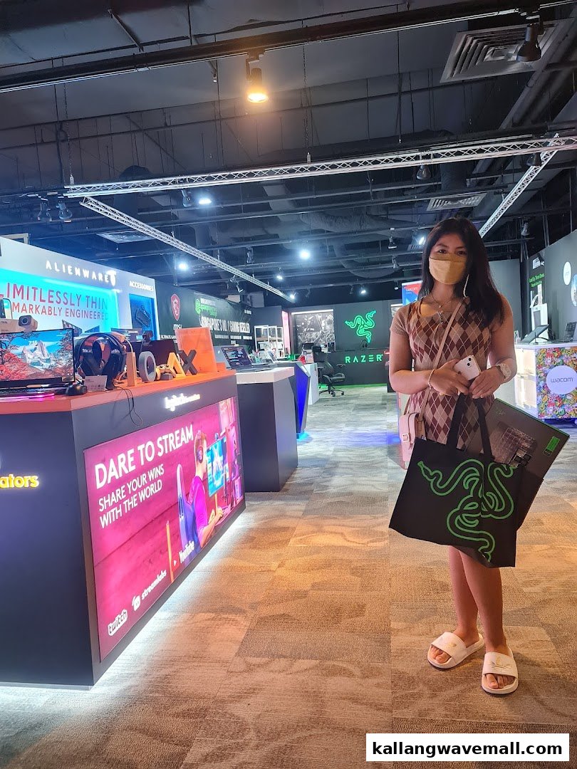 A person stands inside the Esports Experience Center, surrounded by gaming displays and tech products.
