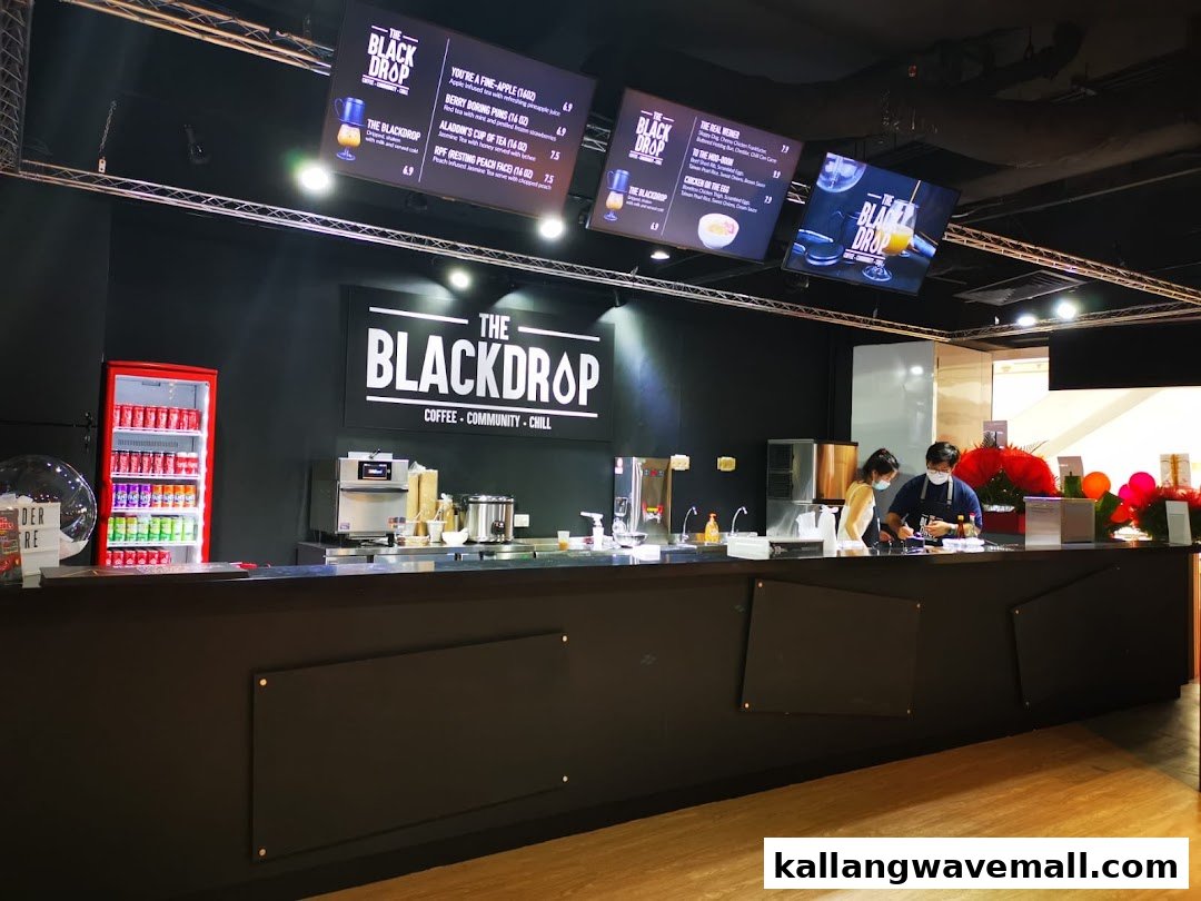 An inviting coffee and chill bar named 'The Blackdrop' with digital menus and staff serving customers.