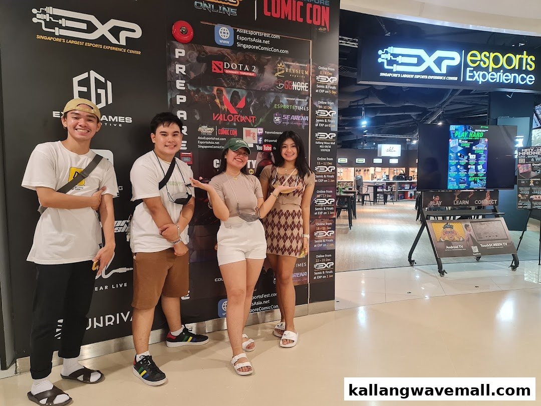 Four people pose outside the entrance of the Esports Experience Center, showcasing the vibrant gaming hub.