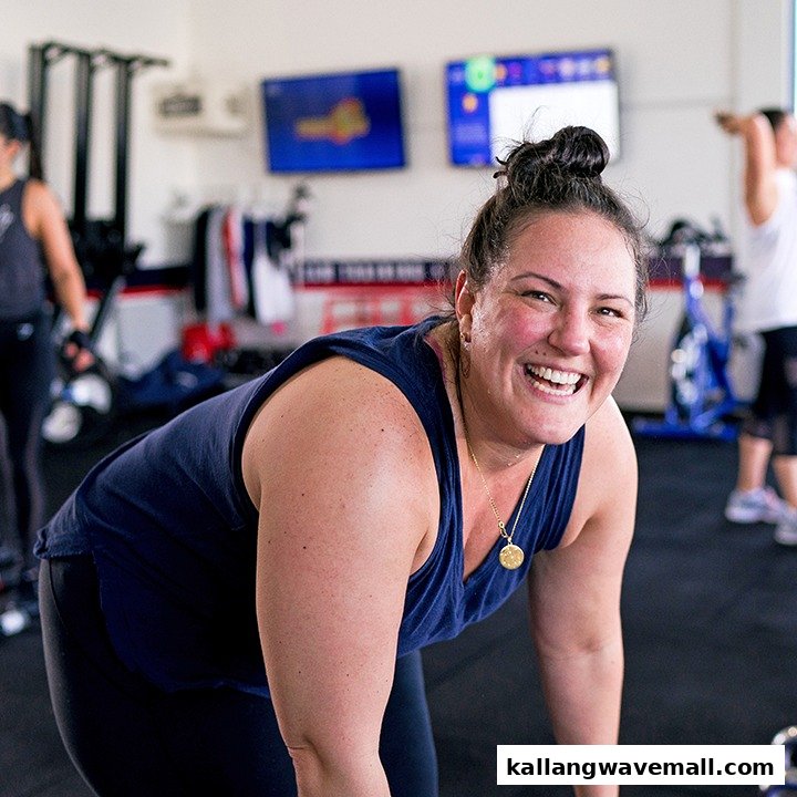 A smiling woman in athletic wear during a high-energy workout session at F45 Training.