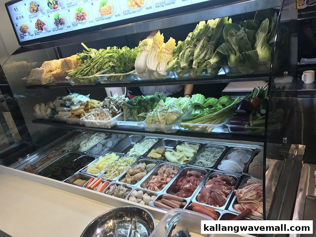 A vibrant display of fresh ingredients and a digital menu board at a food stall.