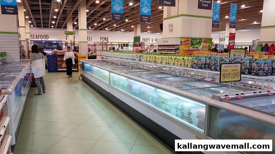 Spacious FairPrice Xtra supermarket interior with long freezer aisles, fresh produce, and shoppers.