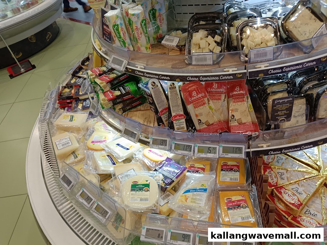 A circular display of various packaged cheeses in a supermarket, featuring Parmesan, Gorgonzola, Cheddar, and Brie.